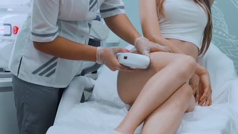 Laser-Haarentfernung-In-Einer-Schönheitsklinik,-Nahaufnahme-Der-Beine-Einer-Frau-Während-Der-Epilation-In-Zeitlupe.-Konzept-Der-Schönheitskosmetik-Für-Frauen